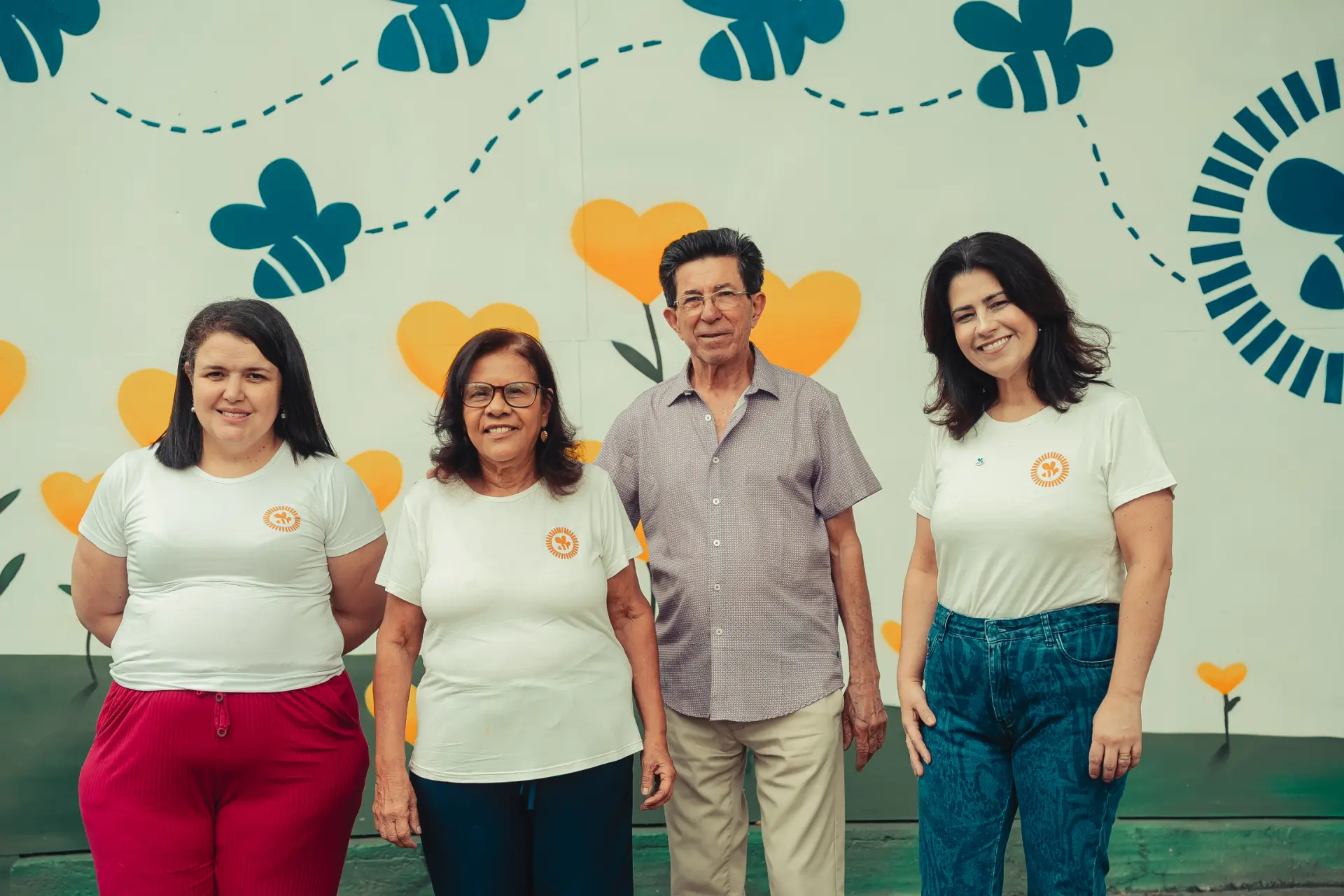 Participantes posando em frente ao mural de abelhas