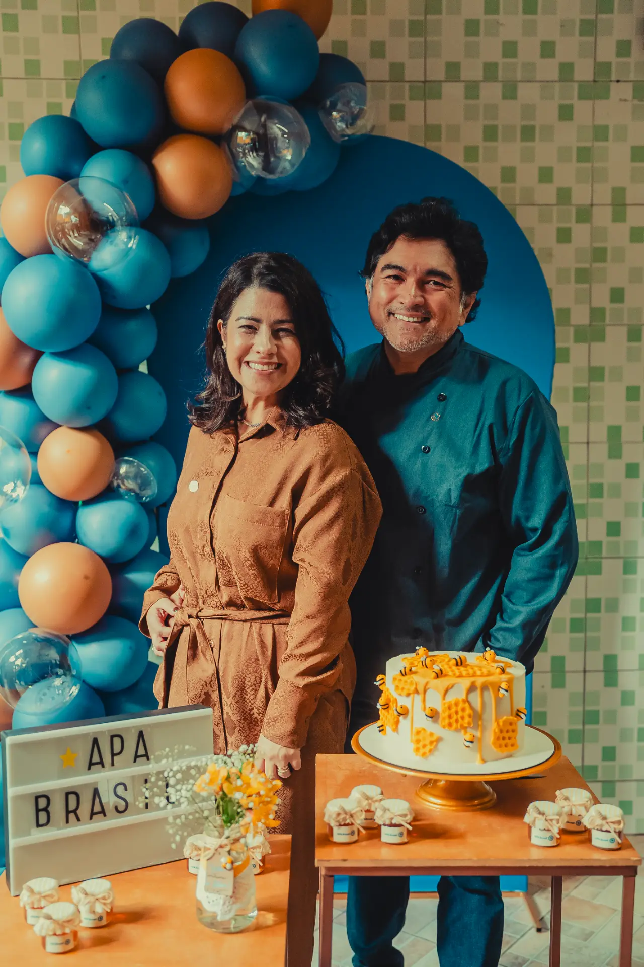 Participantes da inauguração ao lado do letreiro da APA Brasil e do bolo